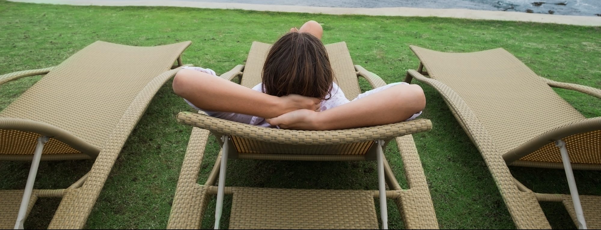 Woman relaxing in Rattan Sun Loungers