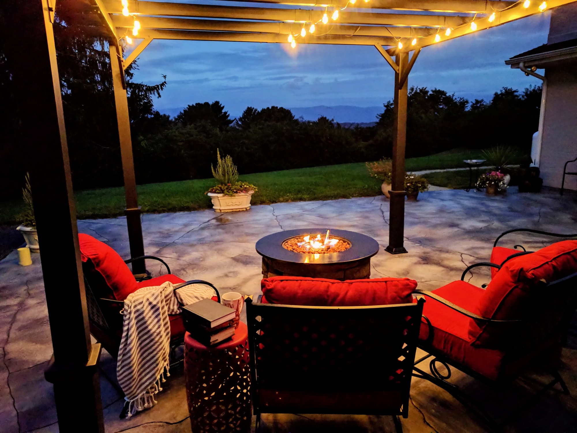 Outdoor living space with a gas fire pit in early morning on our back patio porch