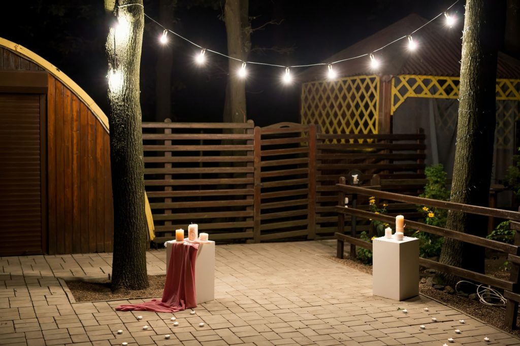 Garden with a wooden gazebo with lights, candles at night at a wedding Garden with a wooden gazebo with lights, candles at night at a wedding