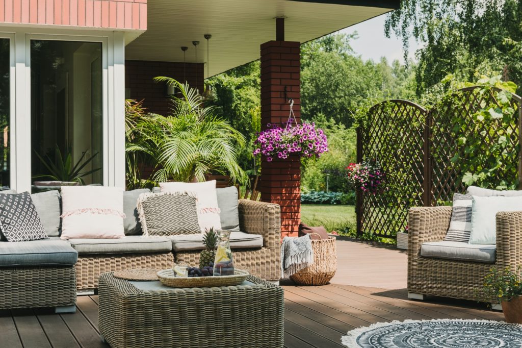 Classy furniture on wooden terrace in green beautiful garden